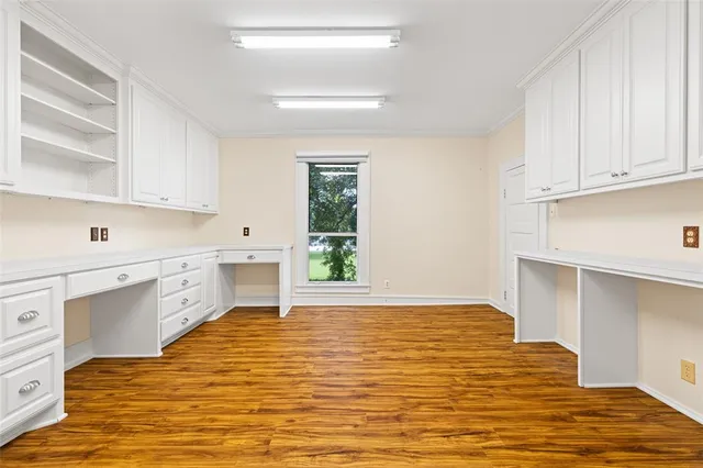 a view of a kitchen with granite countertop white cabinets and wooden floor
