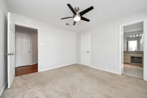 an empty room with closet and a ceiling fan