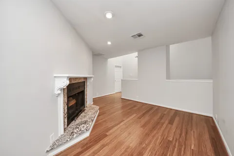 a view of empty room with wooden floor and fireplace