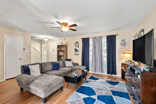 a living room with furniture flat screen tv and a refrigerator