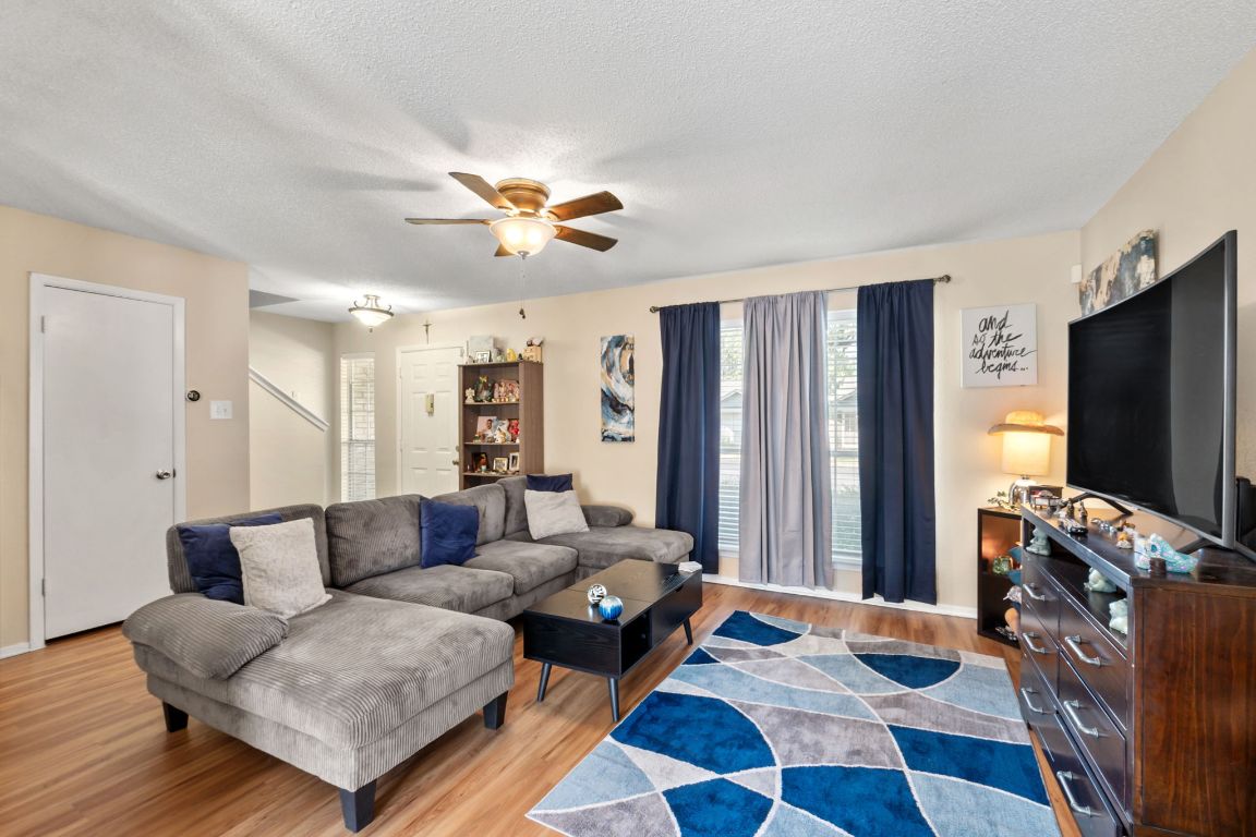 a living room with furniture flat screen tv and a refrigerator