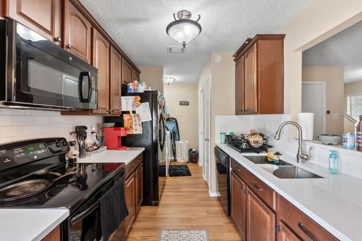 1015 East Yager Lane, Unit 56 Austin, TX 78753 - Photo 4 of 9 a kitchen with a sink stove and cabinets