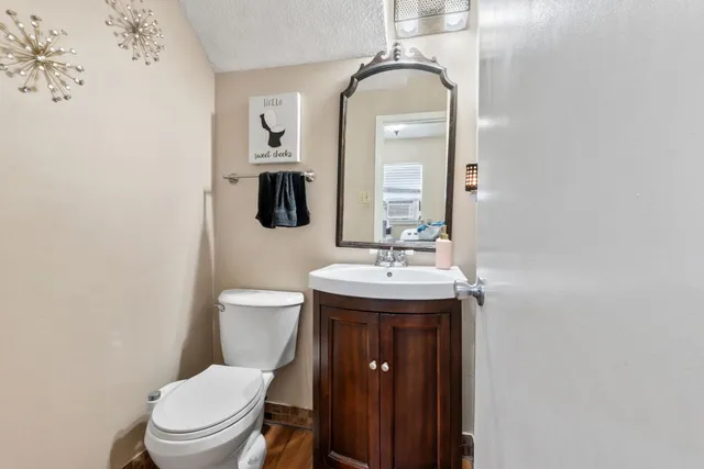 a bathroom with a toilet sink and mirror