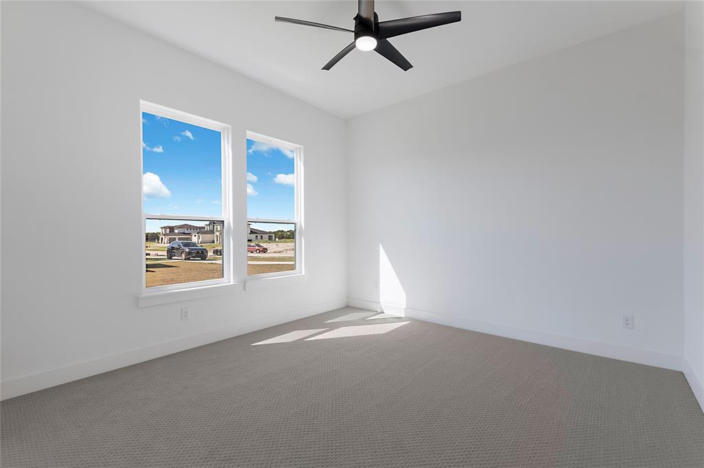 430 Whispering Way Red Oak, TX 75154 - Photo 33 of 40 Contemporary interior featuring two large double-hung windows, a modern ceiling fan with integrated lighting, pristine white walls, and plush carpet flooring