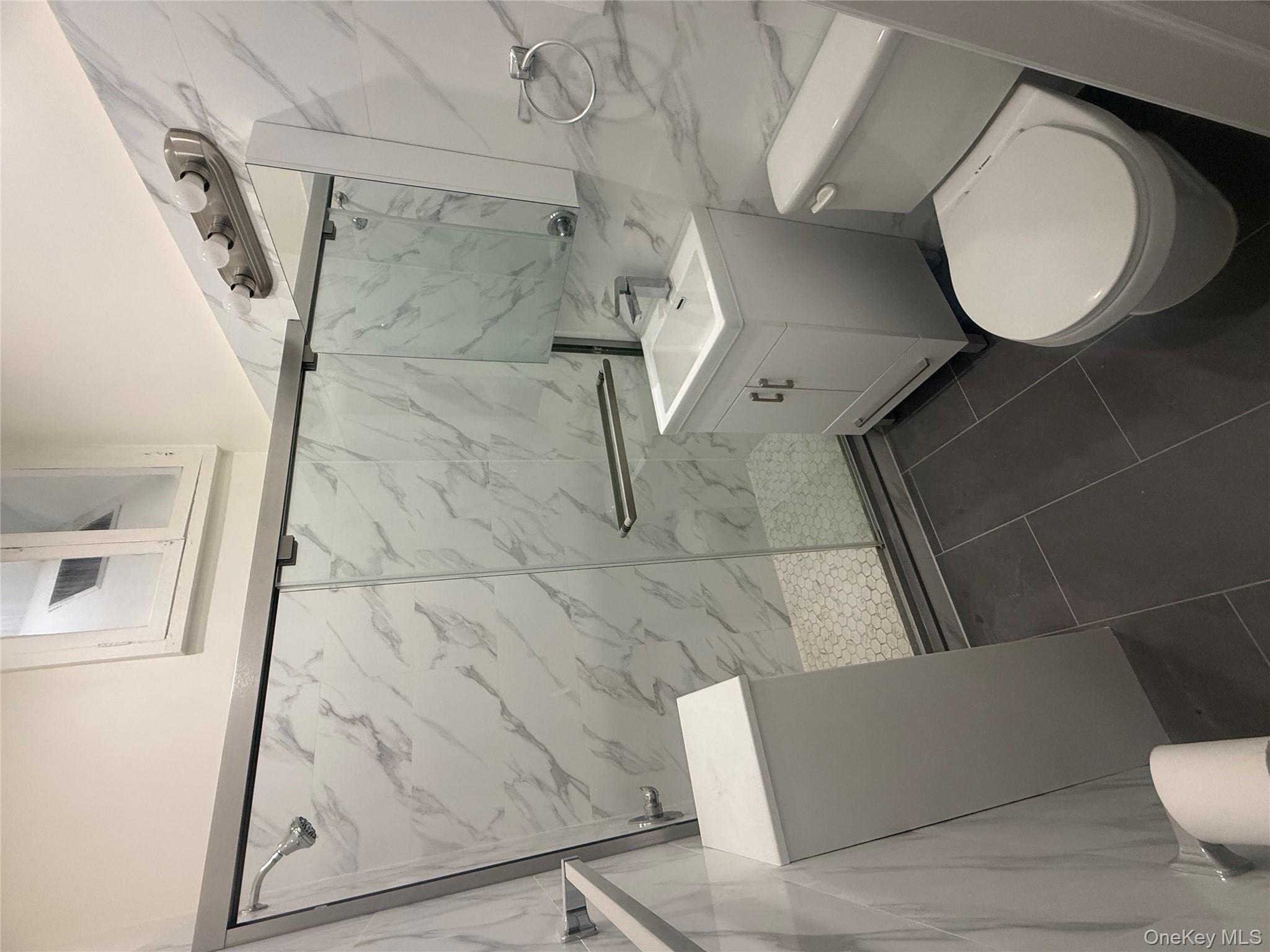 151 Tulip Avenue, Unit 1 Floral Park, NY 11001 - Photo 2 of 3 a white toilet sitting next to a bathroom sink