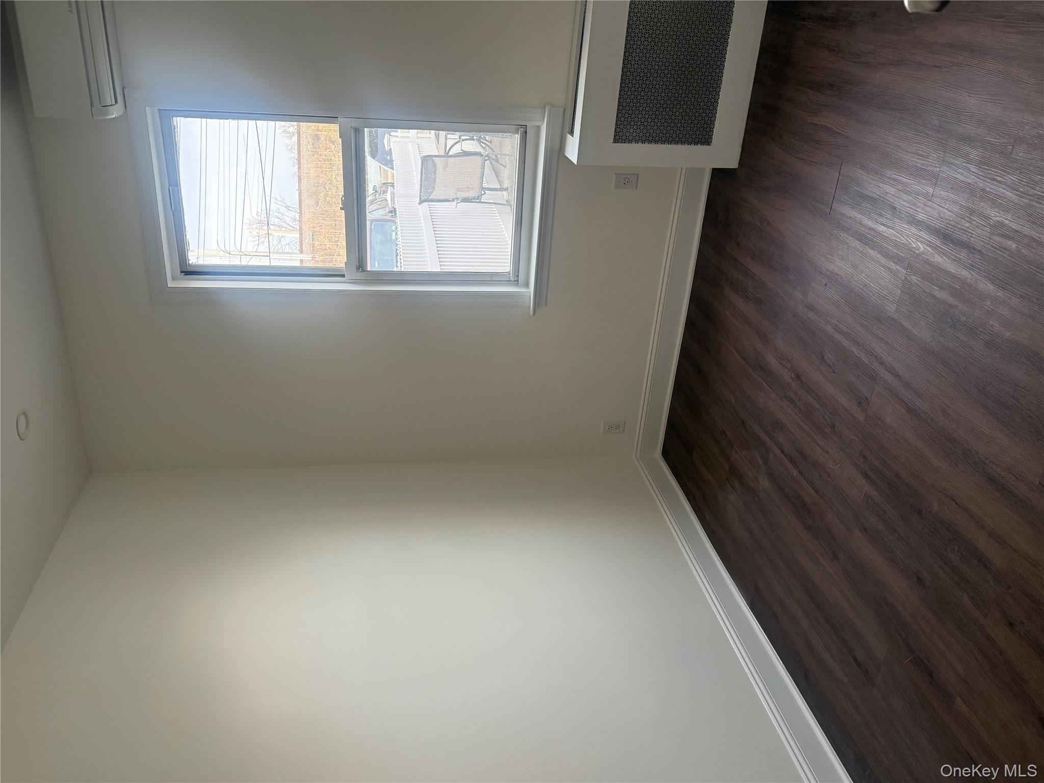151 Tulip Avenue, Unit 1 Floral Park, NY 11001 - Photo 3 of 3 an empty room with wooden floor and windows