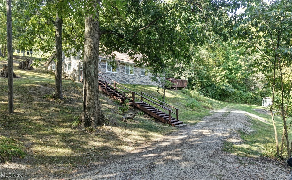 2227 Elk Road Southwest Carrollton, OH 44615 - Photo 20 of 40 View of home's community with stairway, a lawn, and a wooden deck