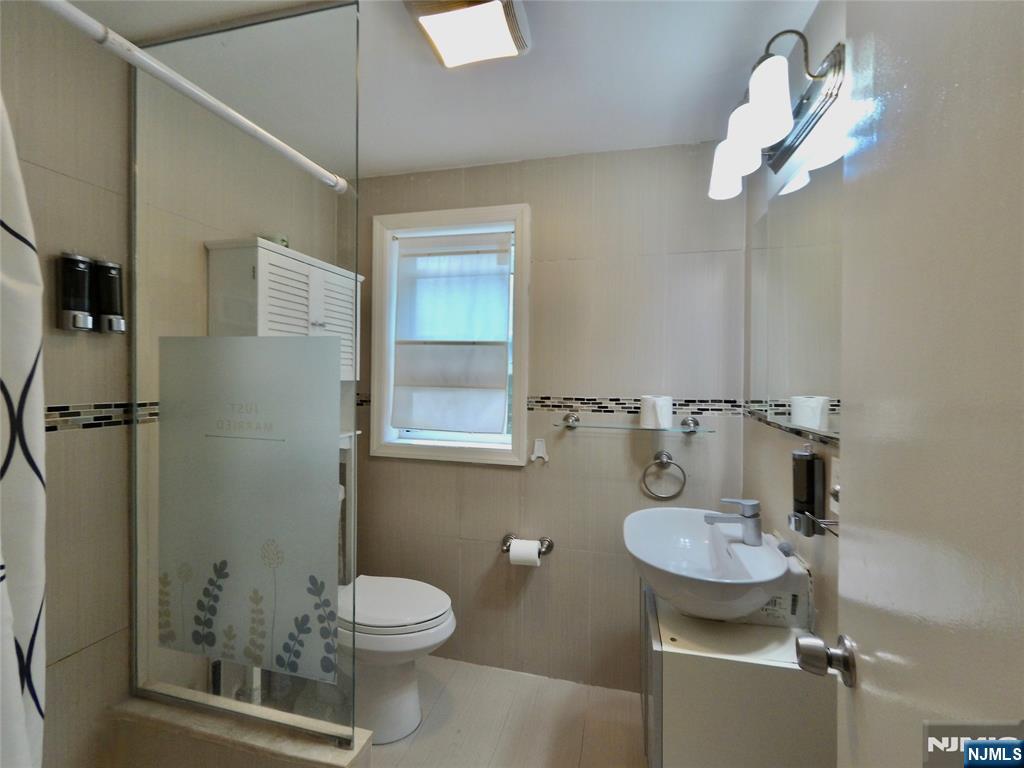 62 Howland Avenue Teaneck, NJ 07666 - Photo 11 of 31 a bathroom with a sink a toilet and shower