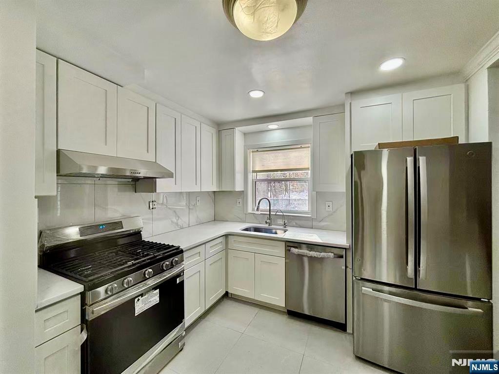 62 Howland Avenue Teaneck, NJ 07666 - Photo 5 of 31 a kitchen with appliances a sink and a window
