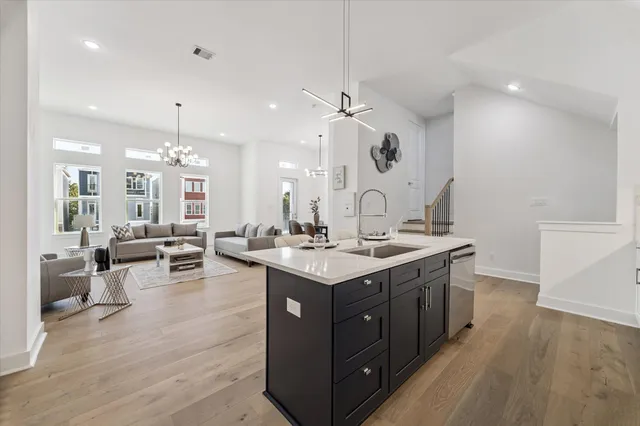 a kitchen with a sink dishwasher and a stove with wooden floor