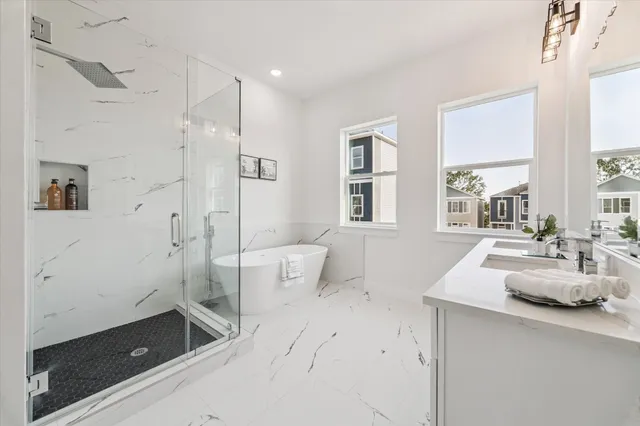 a spacious bathroom with a granite countertop sink a toilet a shower and a window