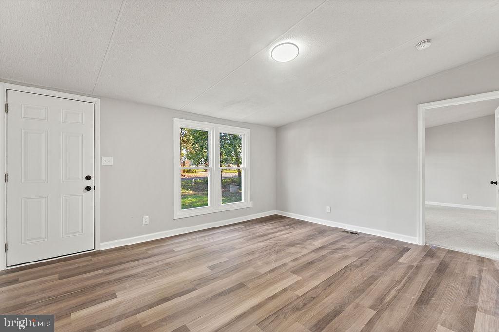 7261 Blanton Road Ruther Glen, VA 22546 - Photo 10 of 35 a view of an empty room with wooden floor and a window