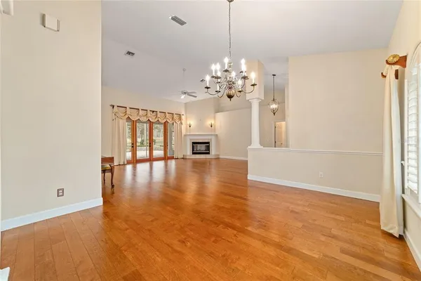 a view of empty room with wooden floor and fireplace