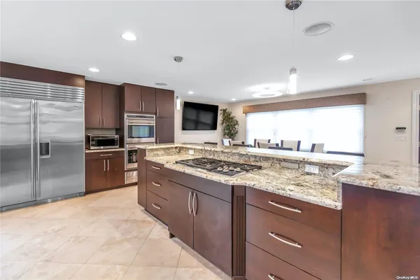 a kitchen with stainless steel appliances granite countertop a stove a sink and a refrigerator
