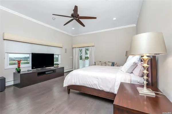 a bedroom with a bed window and a flat screen tv