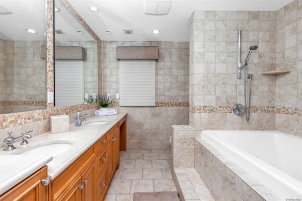 a bathroom with a shower sink vanity mirror and toilet