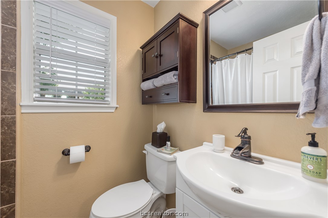 112 Rebecca Street Bryan, TX 77801 - Photo 13 of 18 a bathroom with a sink mirror and toilet