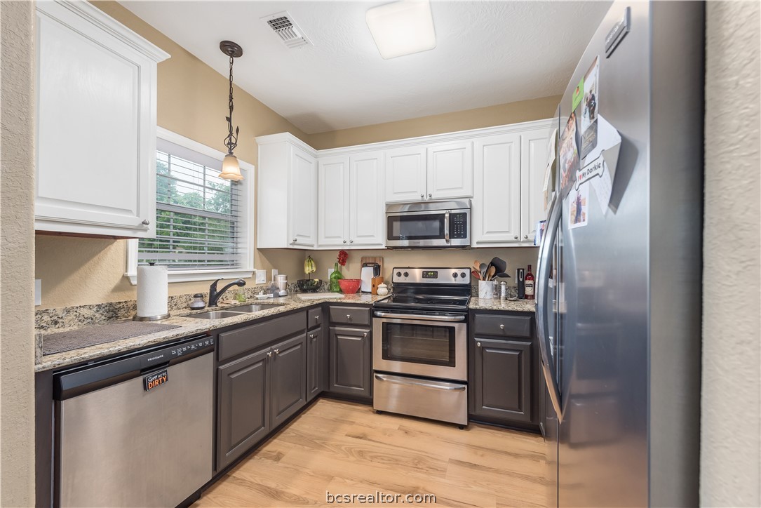112 Rebecca Street Bryan, TX 77801 - Photo 6 of 18 a kitchen with stainless steel appliances granite countertop a sink a stove a refrigerator cabinets and a window