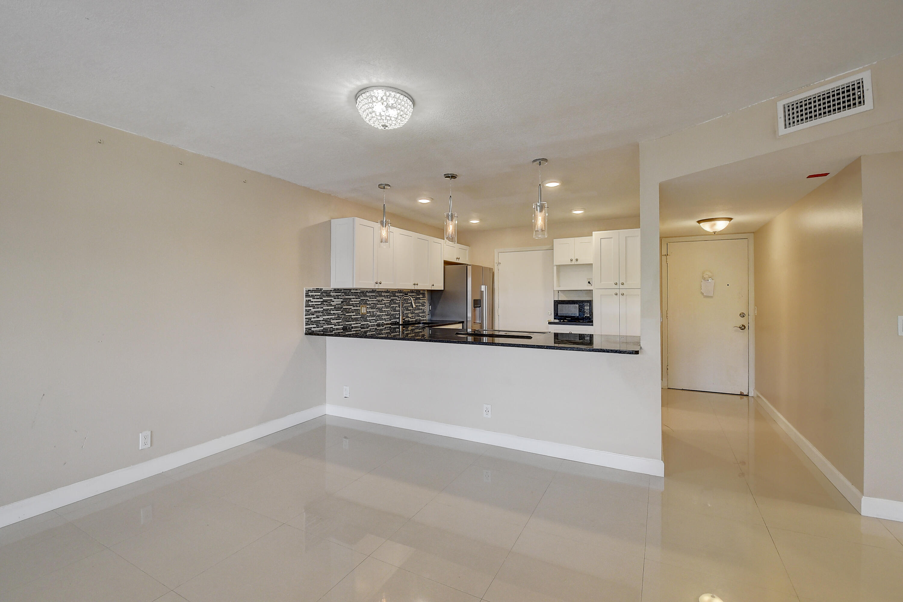 22605 Southwest 66th Avenue, Unit 304 Boca Raton, FL 33428 - Photo 9 of 25 living room looking into kitchen