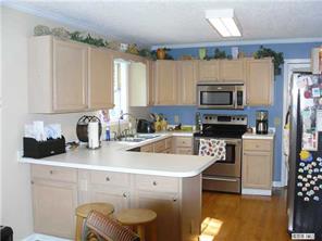 8009 Larkhaven Road Charlotte, NC 28216 - Photo 4 of 16 a kitchen with a sink a stove a microwave and wooden cabinets