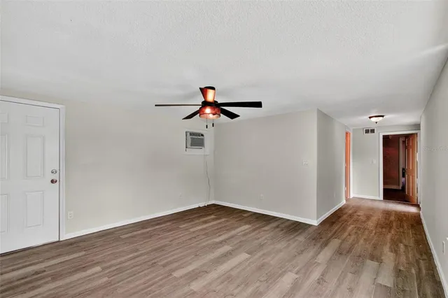 a view of empty room with wooden floor