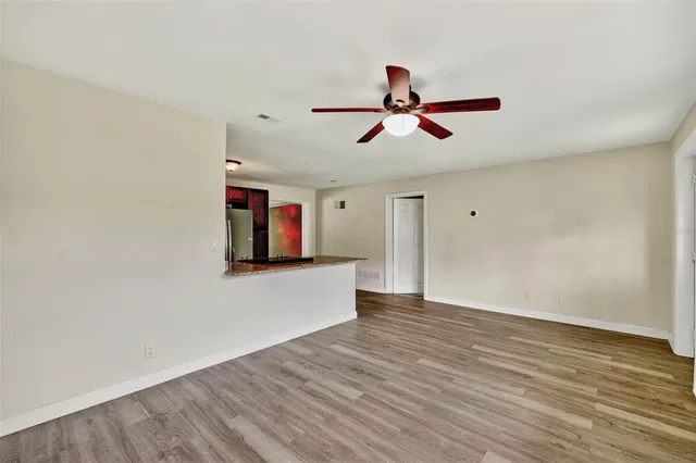 a view of room with wooden floor and ceiling fan