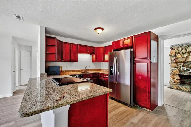 a kitchen with stainless steel appliances granite countertop a refrigerator and a sink