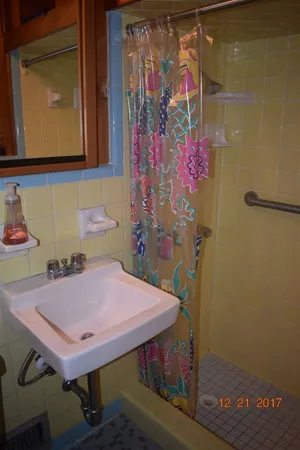 a view of a white house with a small yard and potted plants