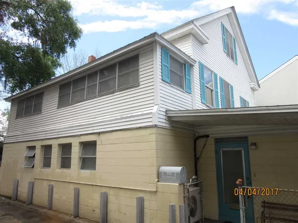 a view of a house with a garage and balcony