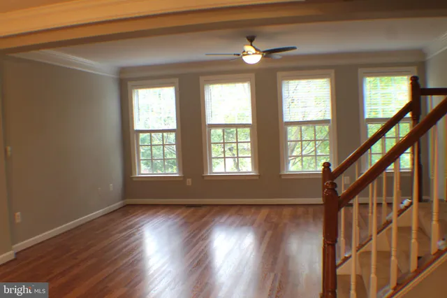 a view of empty room with wooden floor