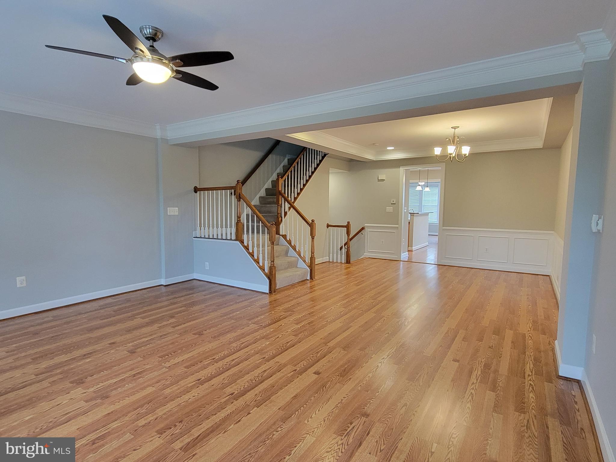 11837 Whitworth Cannon Lane Bristow, VA 20136 - Photo 16 of 63 a view of an empty room with wooden floor a ceiling fan