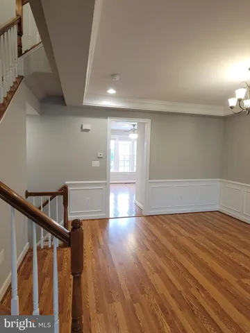 a kitchen with stainless steel appliances kitchen island granite countertop a stove a refrigerator a sink a dining table and chairs with wooden floor