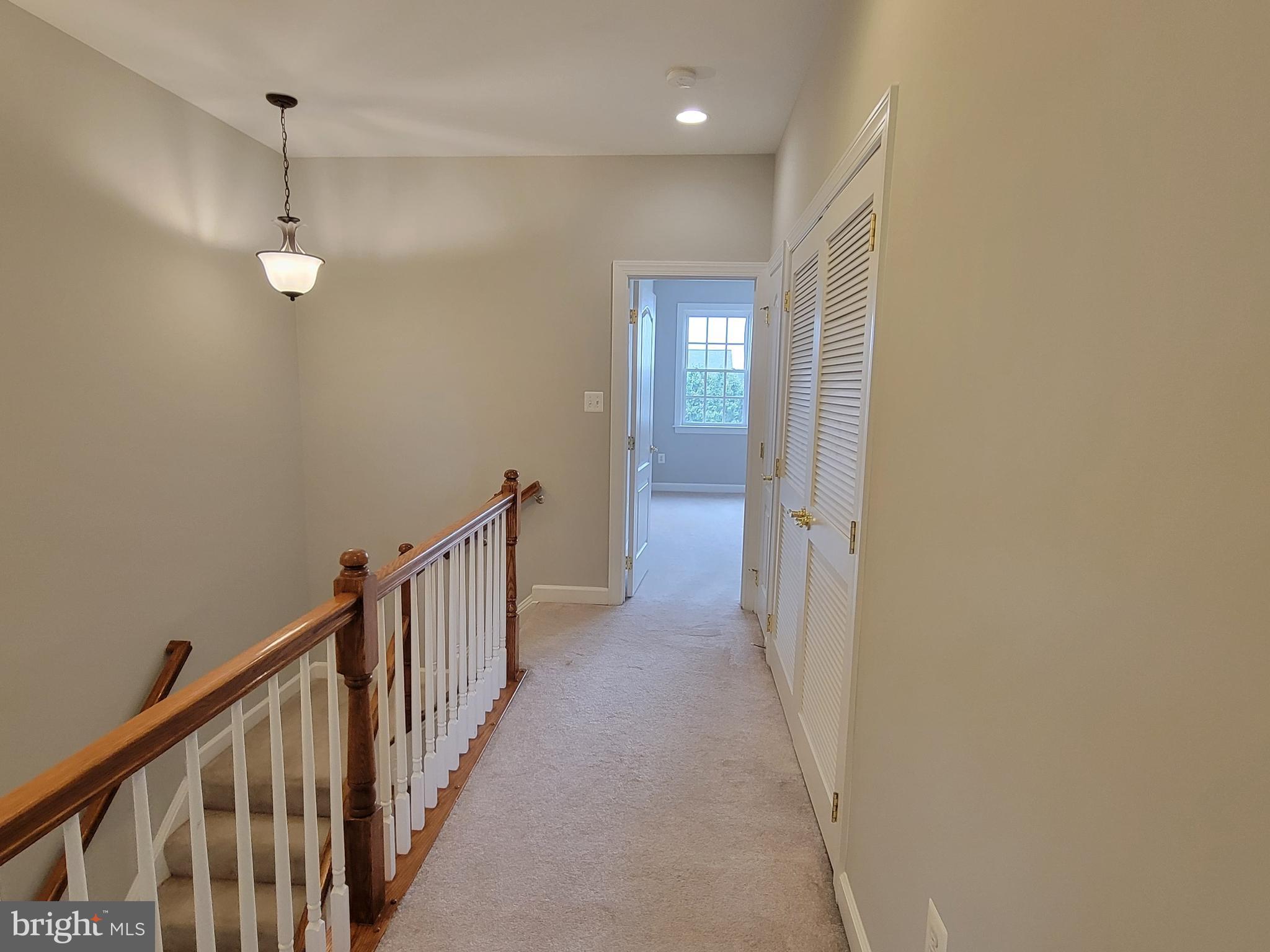 11837 Whitworth Cannon Lane Bristow, VA 20136 - Photo 35 of 63 a view of a hallway with wooden floor and staircase