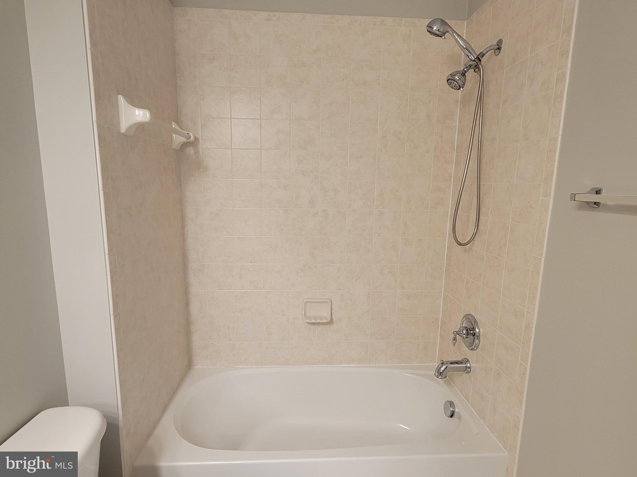 11837 Whitworth Cannon Lane Bristow, VA 20136 - Photo 56 of 63 a bathroom with a bath tub with a shower