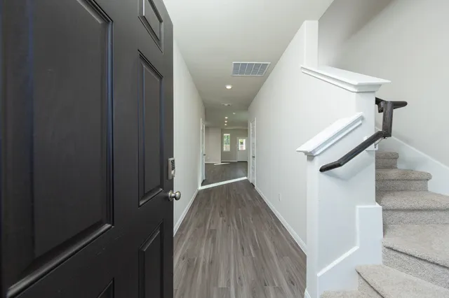 a view of entryway and gallery with wooden floor