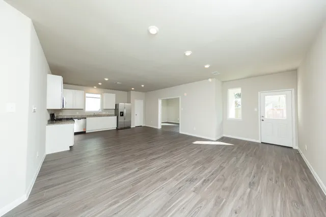 a view of kitchen with stove and wooden cabinets