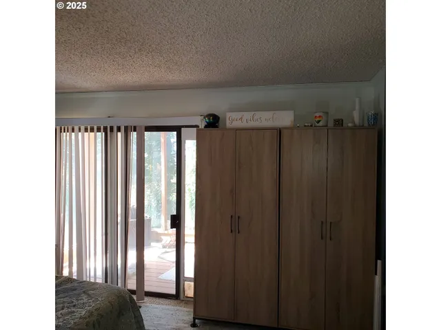 a view of closet with window and hardwood