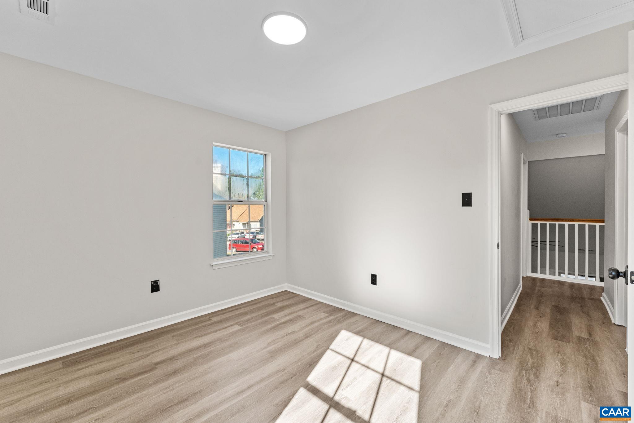 403 Riverside Avenue Charlottesville, VA 22902 - Photo 21 of 27 an empty room with wooden floor and windows