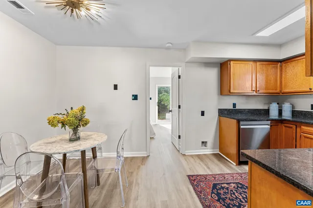 a kitchen with stainless steel appliances granite countertop a stove a sink dishwasher and a refrigerator with wooden floor