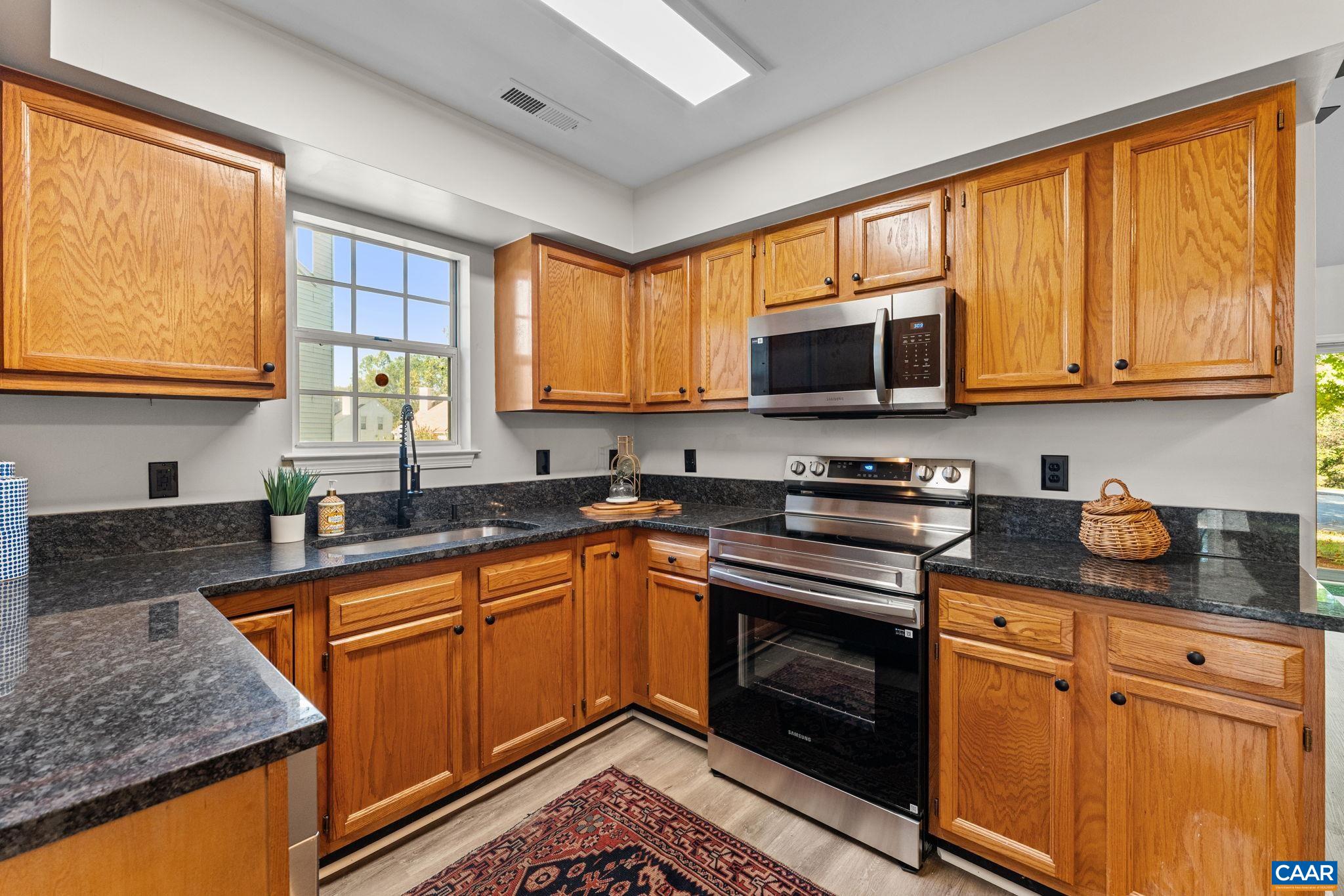 403 Riverside Avenue Charlottesville, VA 22902 - Photo 10 of 27 a kitchen with stainless steel appliances granite countertop wooden cabinets stove top oven and sink