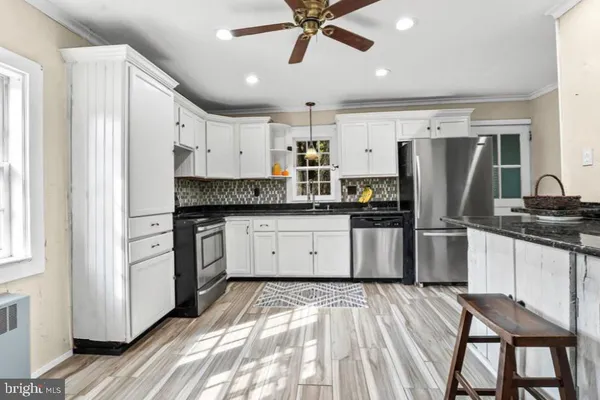 a kitchen with white cabinets and stainless steel appliances