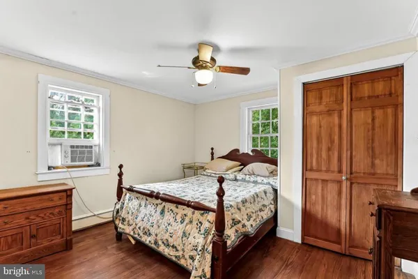 a bedroom with a bed and wooden floors