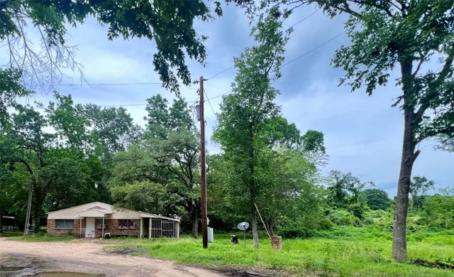 a front view of a house with a yard and trees