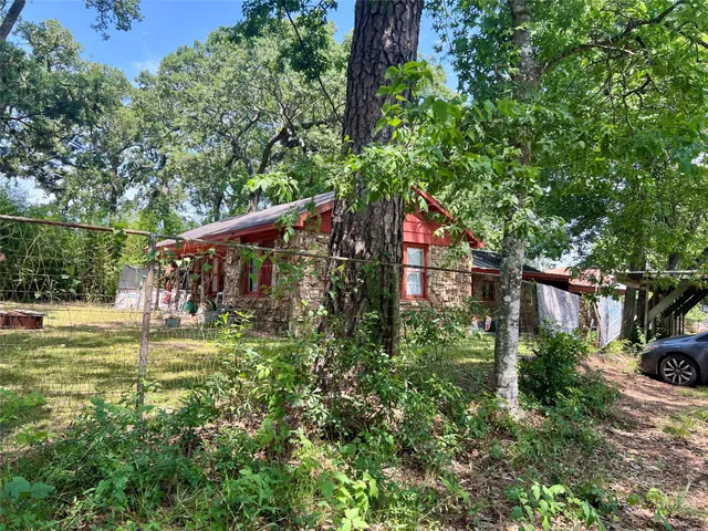 a backyard of a house with lots of green space and fountain