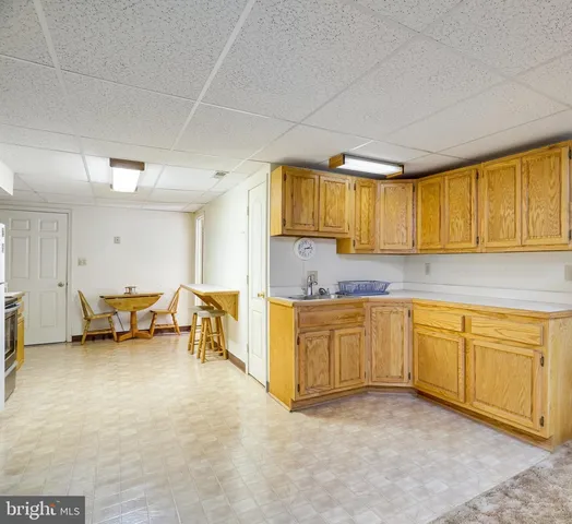 a kitchen with sink cabinets and living room