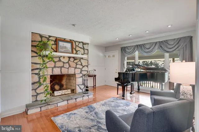 a living room with furniture a fireplace and wooden floor