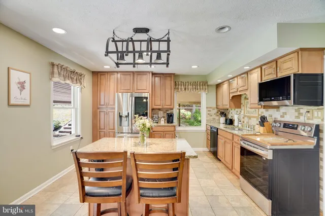 a kitchen with a counter space a sink appliances and cabinets