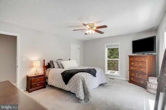 a spacious bedroom with a bed and a flat screen tv