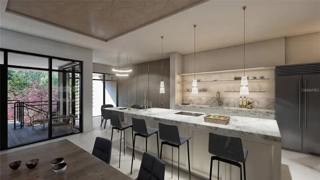 a kitchen with stainless steel appliances kitchen island granite countertop a table chairs and a refrigerator