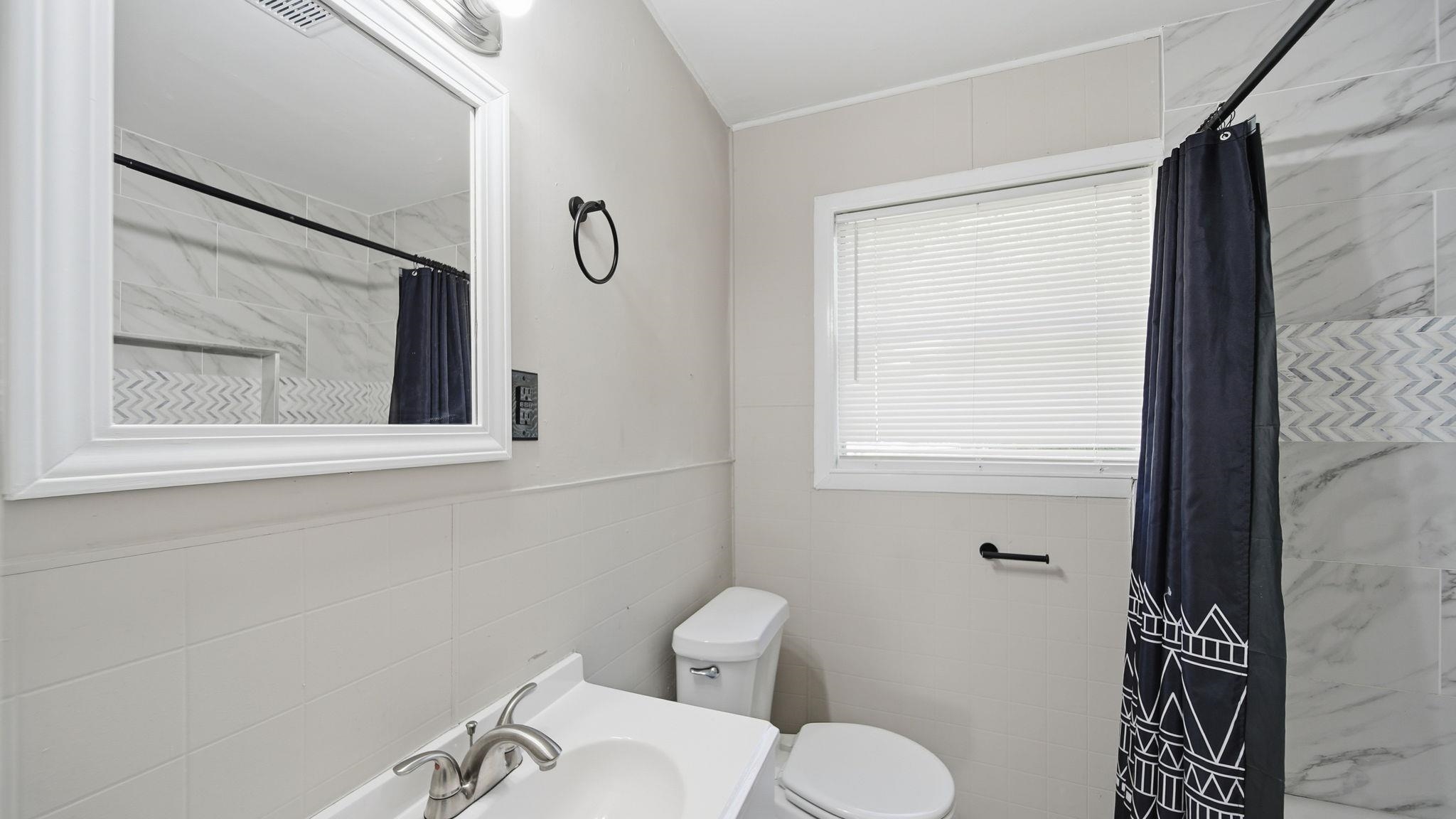 3531 Randolph Street Memphis, TN 38127 - Photo 17 of 32 a bathroom with a toilet sink and mirror